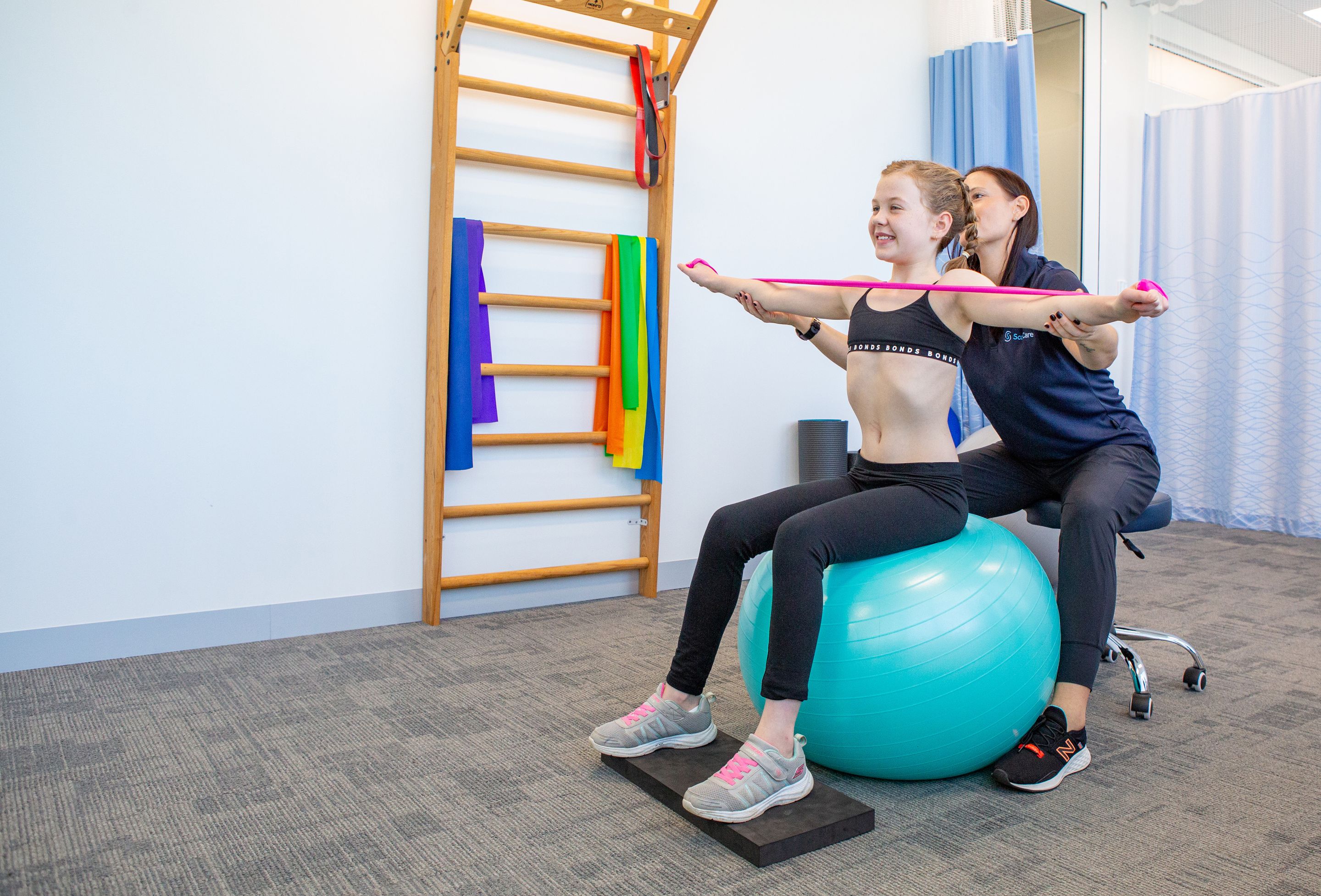 ScoliBalance image of physiotherapist helping young patient perform exercise